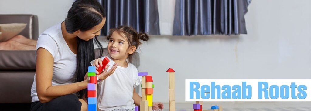 A mother and daughter engaging in speech therapy using colorful building blocks, symbolizing developmental support and communication enhancement at Rehaab Roots.